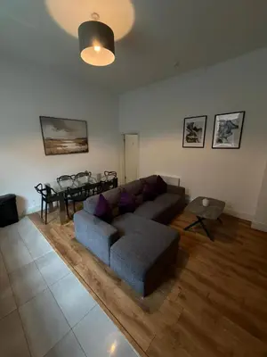 a living room with a couch and a table at Spacious 4 Bedroom Apartment with Terrace Liverpool by StaySavvy Accommodation in Liverpool