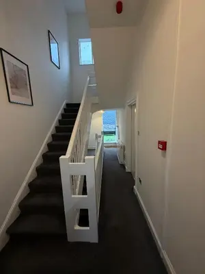 a staircase in a house with a white stair case at Spacious 4 Bedroom Apartment with Terrace Liverpool by StaySavvy Accommodation in Liverpool
