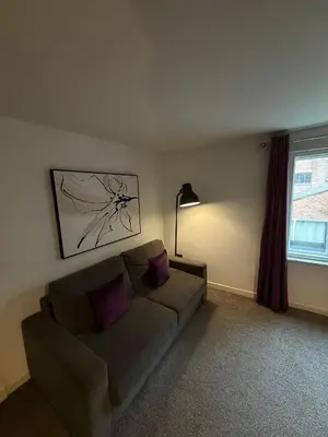 a living room with a couch and a window at Spacious 4 Bedroom Apartment with Terrace Liverpool by StaySavvy Accommodation in Liverpool