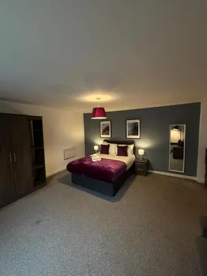 a bedroom with a bed with a red blanket and two mirrors at Spacious 4 Bedroom Apartment with Terrace Liverpool by StaySavvy Accommodation in Liverpool