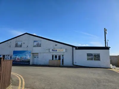 a white building with a sign on the side of it at Carol & Nick's holiday home in Heysham