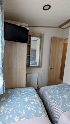 a small bedroom with a bed and a window at Carol & Nick's holiday home in Heysham