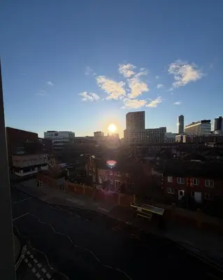 a view of a city skyline with the sun setting at 2-Bed City View with Balcony Liverpool by StaySavvy Accommodation in Liverpool