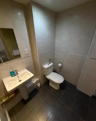 a bathroom with a white toilet and a sink at 2-Bed City View with Balcony Liverpool by StaySavvy Accommodation in Liverpool