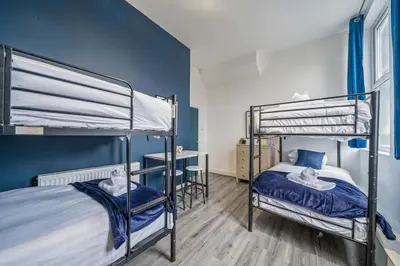a bedroom with two bunk beds with blue walls at Spacious City Flat - 2 Bedrooms - Sleeps 7 in Liverpool