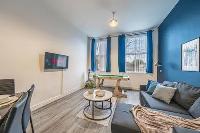 a living room with a couch and a pool table at Spacious City Flat - 2 Bedrooms - Sleeps 7 in Liverpool