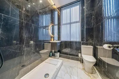 a bathroom with a toilet and a tub and a sink at Spacious City Flat - 2 Bedrooms - Sleeps 7 in Liverpool