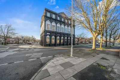 a large black building on a street with a tree at Spacious City Flat - 2 Bedrooms - Sleeps 7 in Liverpool