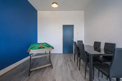 a room with a ping pong table and chairs at Comfortable 2BR Flat - Sleeps 6 - Ideal City Stays in Liverpool