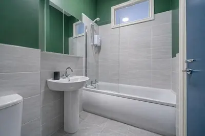 a bathroom with a sink and a tub and a toilet at Comfortable 2BR Flat - Sleeps 6 - Ideal City Stays in Liverpool