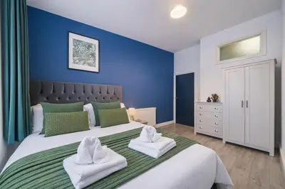 a bedroom with a large bed with towels on it at Comfortable 2BR Flat - Sleeps 6 - Ideal City Stays in Liverpool