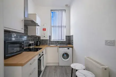 a kitchen with a sink and a washing machine at Large 2-Bedroom Flat Sleeps 7 - Perfect for Groups in Liverpool