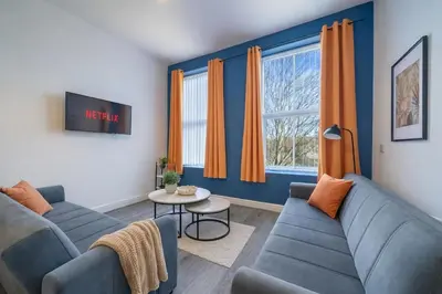 a living room with two blue couches and a table at Large 2-Bedroom Flat Sleeps 7 - Perfect for Groups in Liverpool