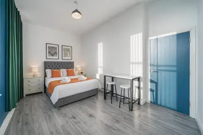 a bedroom with a bed and a table and a desk at Large 2-Bedroom Flat Sleeps 7 - Perfect for Groups in Liverpool
