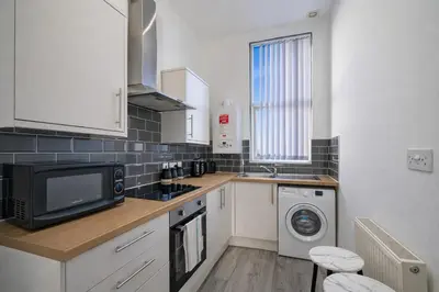 a kitchen with a microwave oven and a sink at Large 2-Bedroom Flat Sleeps 7 - Perfect for Groups in Liverpool
