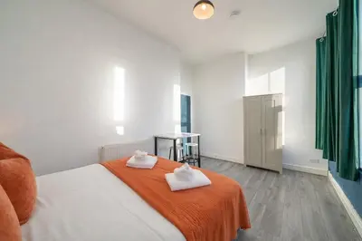 a bedroom with a bed with two towels on it at Large 2-Bedroom Flat Sleeps 7 - Perfect for Groups in Liverpool
