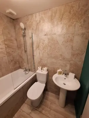 a bathroom with a toilet and a sink and a shower at King's Haven in Southport