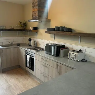 a kitchen with a stove top oven and a microwave at King's Haven in Southport