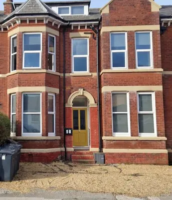 a red brick house with a yellow door at King's Haven in Southport