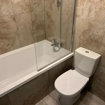 a bathroom with a toilet and a shower and a tub at King's Haven in Southport