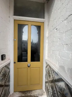 a yellow door on the side of a brick building at King's Haven in Southport