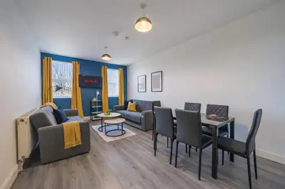 a living room with a couch and a table and chairs at 2BR Flat - 4 Beds Sleeps 7 - Trinity Vaults in Liverpool
