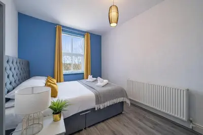 a bedroom with a bed with blue walls and a window at 2BR Flat - 4 Beds Sleeps 7 - Trinity Vaults in Liverpool