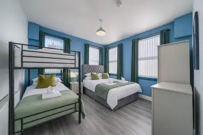 a bedroom with two bunk beds and blue walls at Family-Friendly 2BR Flat - Sleeps 7 in Liverpool