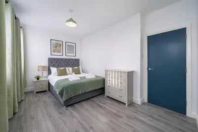a bedroom with a bed and a blue door at Family-Friendly 2BR Flat - Sleeps 7 in Liverpool