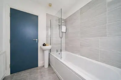 a white bathroom with a tub and a sink at Family-Friendly 2BR Flat - Sleeps 7 in Liverpool