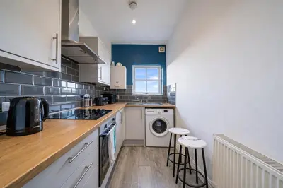 a kitchen with a washer and dryer in it at Family-Friendly 2BR Flat - Sleeps 7 in Liverpool