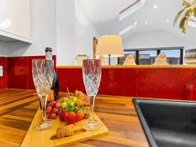 two wine glasses and a basket of fruit on a table at Central Chorley Home Free Parking Fast Wi-Fi in Chorley
