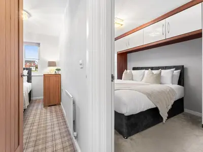 a bedroom with a large bed and a bathroom at Central Chorley Home Free Parking Fast Wi-Fi in Chorley