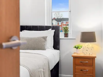 a bedroom with a bed and a window at Central Chorley Home Free Parking Fast Wi-Fi in Chorley