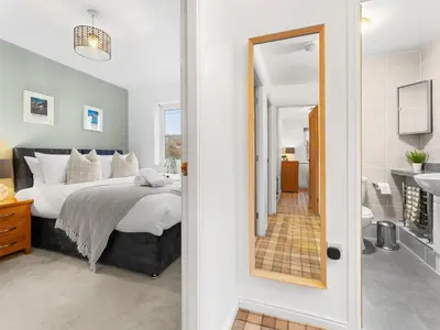 a bedroom with a bed and a bathroom at Central Chorley Home Free Parking Fast Wi-Fi in Chorley