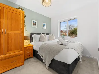 a bedroom with a large bed and a window at Central Chorley Home Free Parking Fast Wi-Fi in Chorley