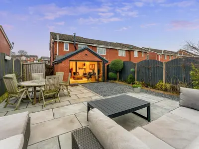 a patio with a table and chairs in a backyard at Central Chorley Home Free Parking Fast Wi-Fi in Chorley