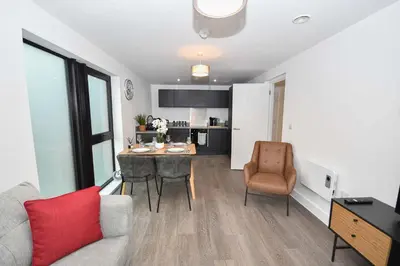 a living room with a table and chairs and a kitchen at Spacious 2 Bed Apartment in Central Liverpool in Liverpool
