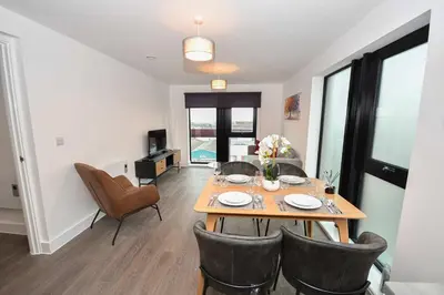 a dining room and living room with a table and chairs at Spacious 2 Bed Apartment in Central Liverpool in Liverpool