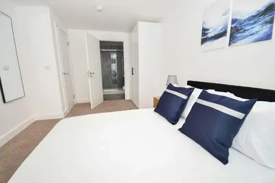 a bedroom with a bed with blue and white pillows at Spacious 2 Bed Apartment in Central Liverpool in Liverpool