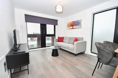 a living room with a couch and a tv at Spacious 2 Bed Apartment in Central Liverpool in Liverpool