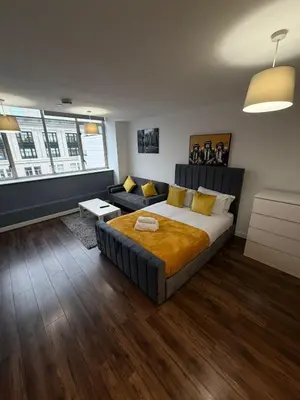a bedroom with a large bed and a couch at City View Studio Apartment Liverpool by StaySavvy Accommodation in Liverpool
