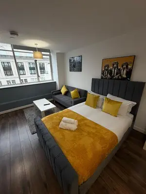 a bedroom with a large bed and a couch at City View Studio Apartment Liverpool by StaySavvy Accommodation in Liverpool