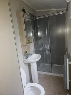 a bathroom with a toilet and a sink and a shower at Crozzer's Place in Heysham