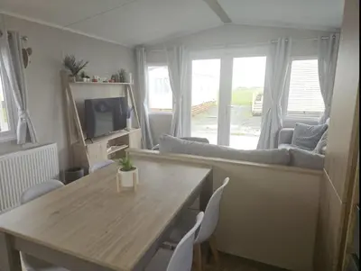 a living room with a table and a couch at Crozzer's Place in Heysham