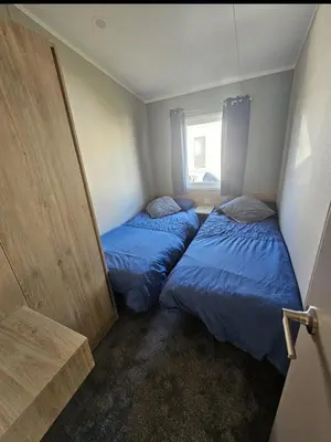 two beds in a small room with a window at Crozzer's Place in Heysham