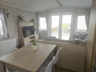a living room with a table and a couch at Crozzer's Place in Heysham