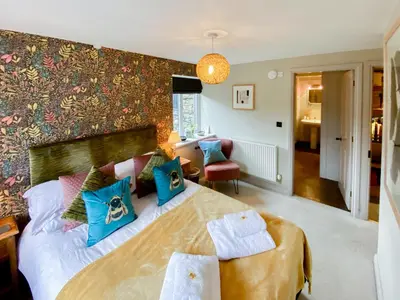 a bedroom with a large bed with blue pillows at Yan Cottage - Uk43540 in Spark Bridge