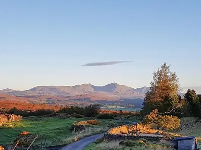a road in a field with mountains in the background at Yan Cottage - Uk43540 in Spark Bridge