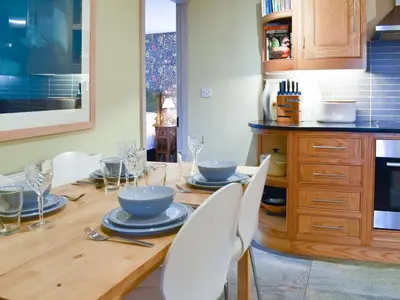 a kitchen with a wooden table with plates and bowls on it at Yan Cottage - Uk43540 in Spark Bridge